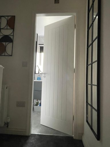 Open door leading to a room with visible light and furniture in the background.
